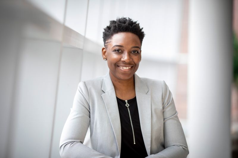 Legal professional in a gray blazer smiling outside her office