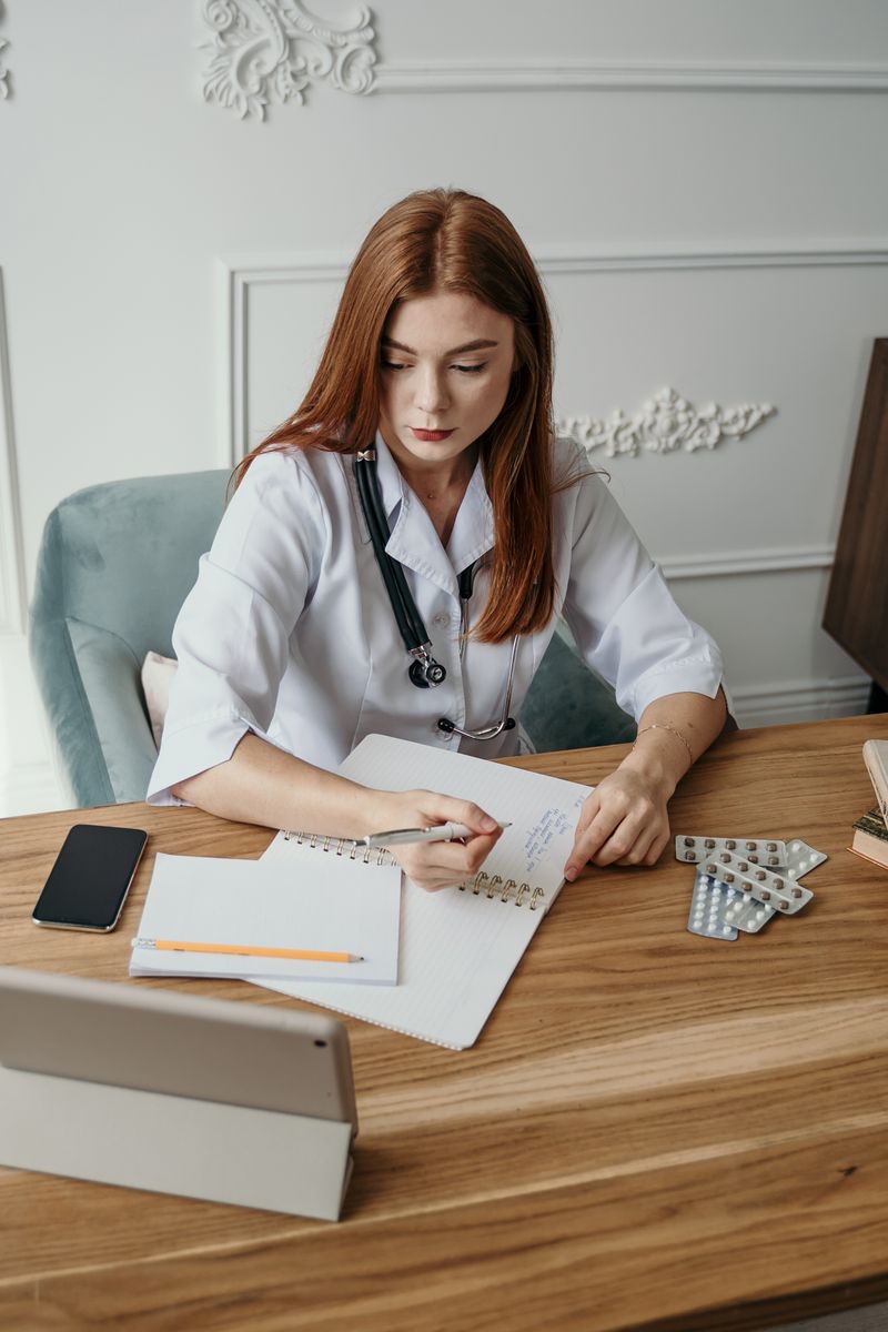 Doctor writing patient notes at her desk in a bright clinic office